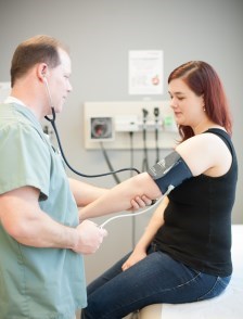 Nurse taking blood pressure of a patient in clinic