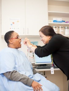Nurse looking in mouth of patient