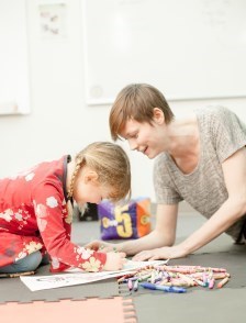 Staff member colouring with small child